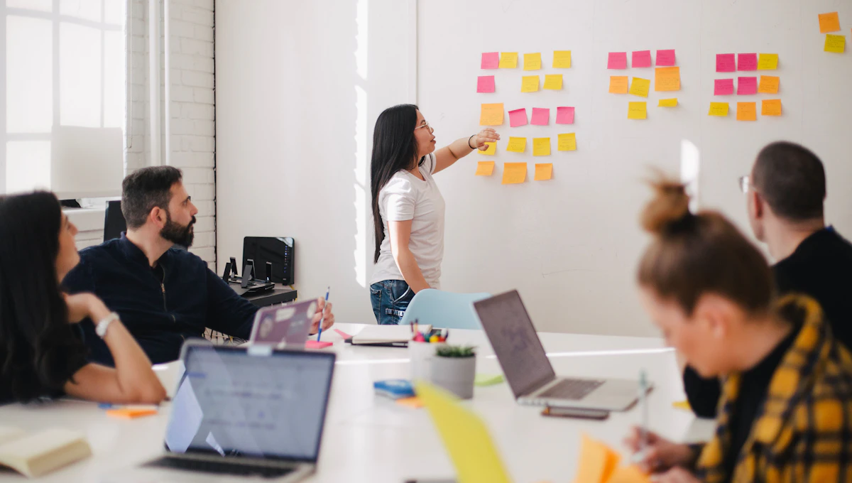 Equipo planificando ideas en notas adhesivas frente a una pizarra
