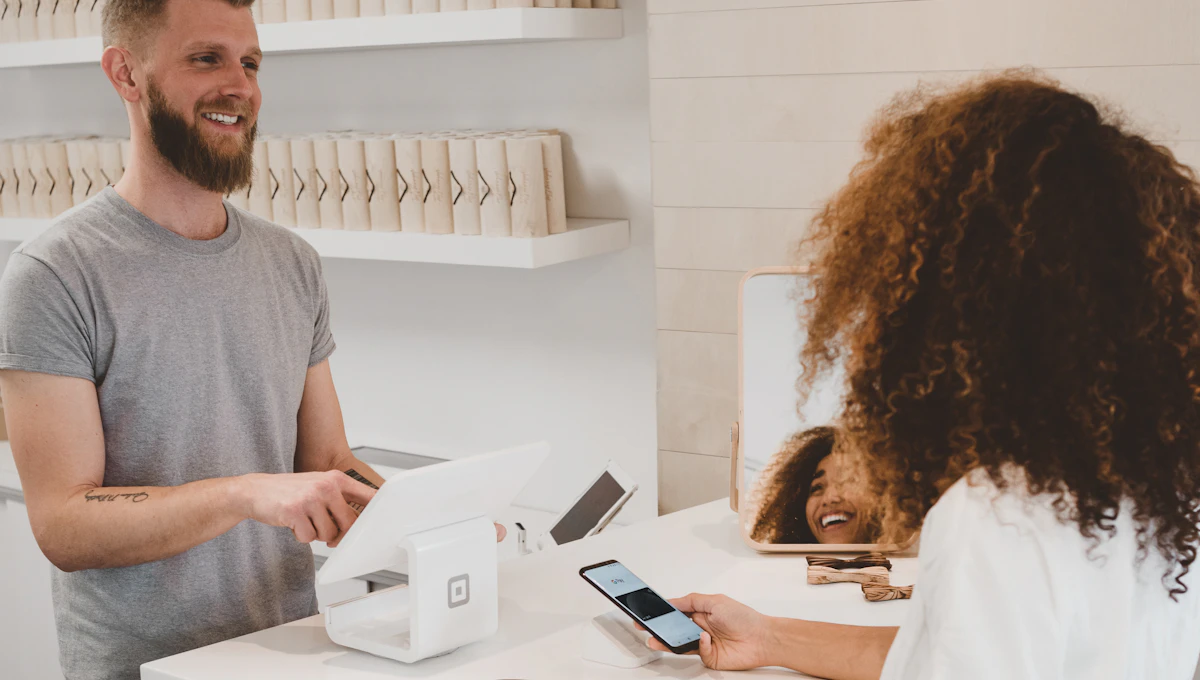 Cliente pagando una compra en un comercio con su teléfono