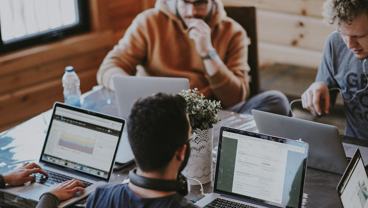 Equipo de trabajo colaborando con computadores portátiles